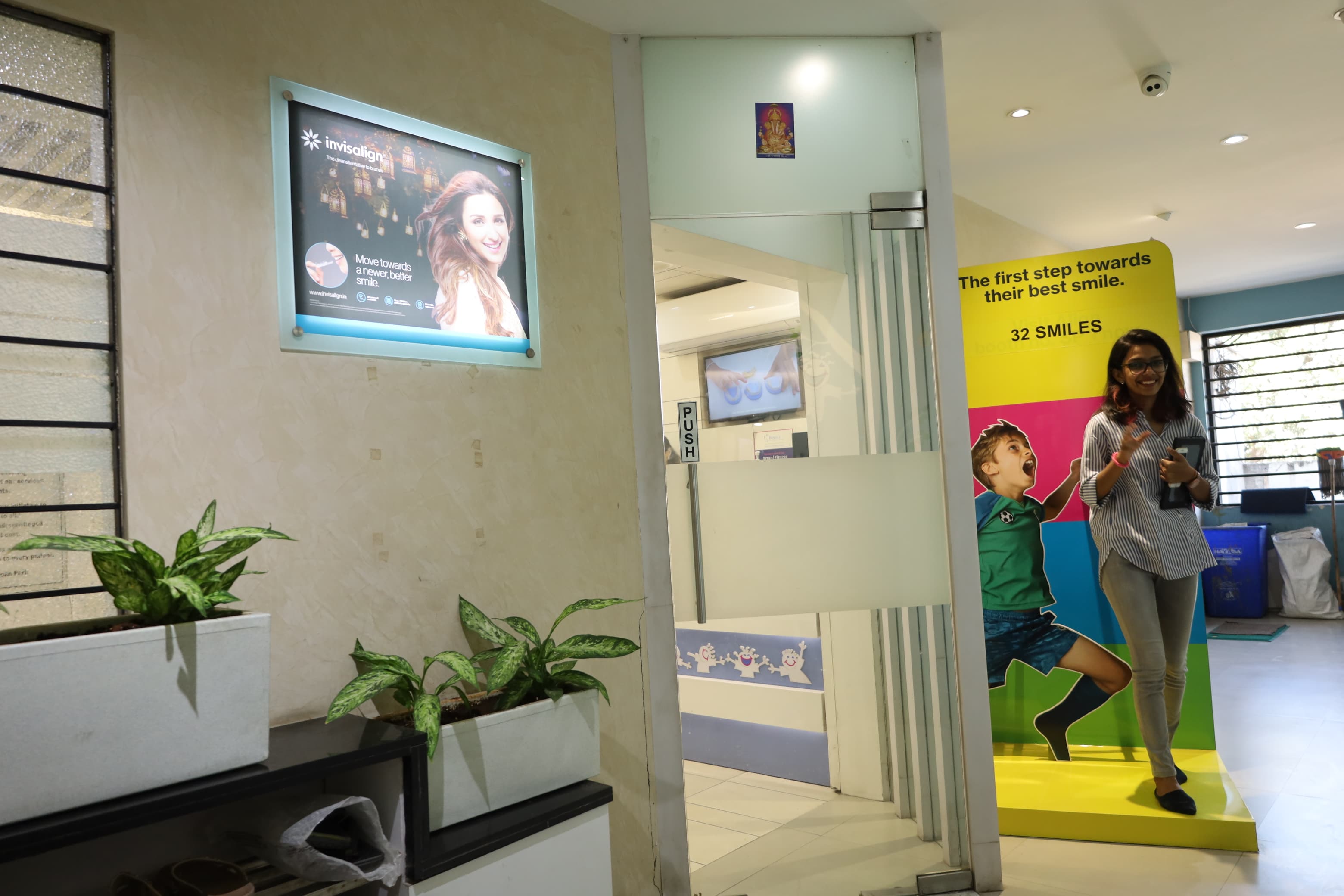 Waiting area at the 32 Smiles J.M. Road clinic, Shivajinagar, with bench seating and a notice board of patient thank-you notes and awards